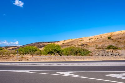 Surface level of road against blue sky