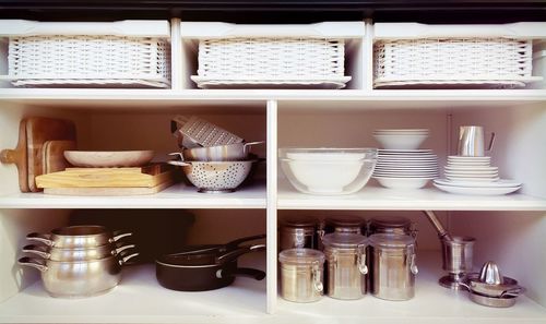 Containers and ceramics arranged in shelves at kitchen