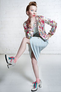 Full length portrait of girl against wall