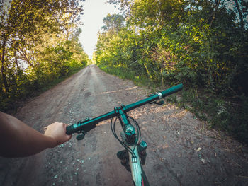 Cropped image of person riding bicycle on road