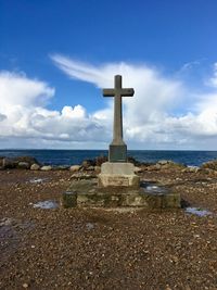 Cross on beach against sky in normandy 