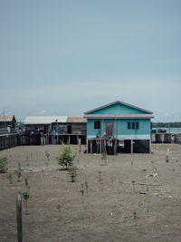 Built structure on beach by buildings against clear sky