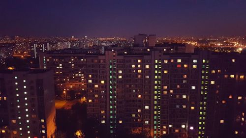 Illuminated buildings in city against sky at night