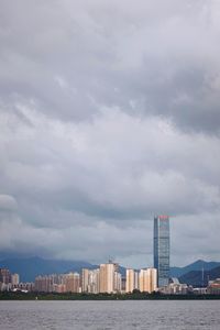 Sea by buildings against sky in city