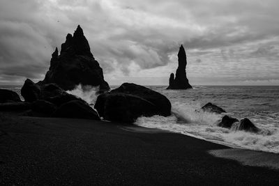 Rocks on beach against sky