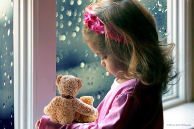 Girl looking through window