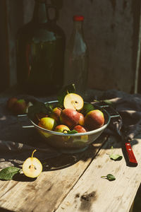 Many ripe pears in a colander on wooden garden table