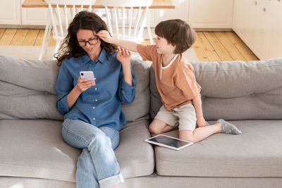 Friends sitting on sofa at home