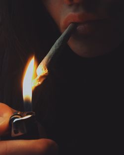 Close-up of hand holding burning candle