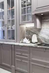 Modern beige and grey colored kitchen interior classic style with marble countertop in apartment.