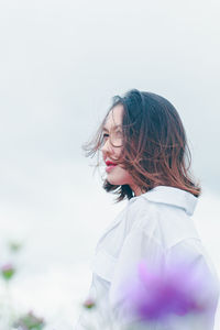 Portrait of woman standing against sky