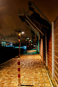 Empty alley amidst buildings at night