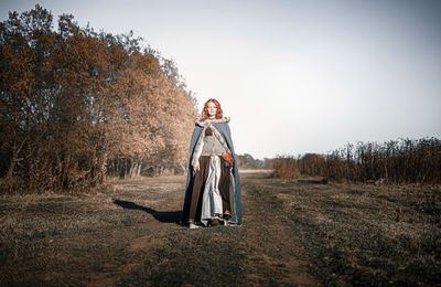 Woman standing on field against sky