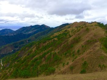 Scenic view of mountains against cloudy sky