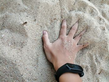 High angle view of hands on sand