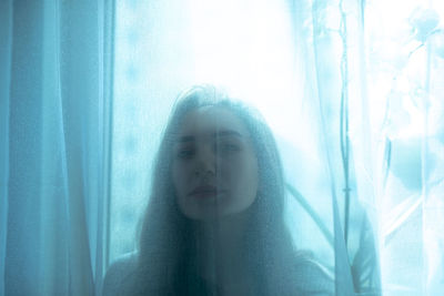 Portrait of woman looking through window