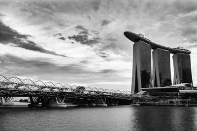 Bridge over river in city against sky