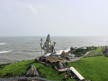 Statue by sea against clear sky