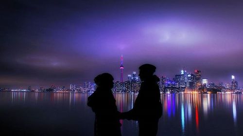 People standing in illuminated city at night