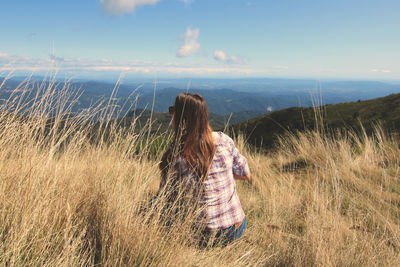 Woman standing on field against sky