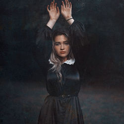 Portrait of young woman standing against in a forest background