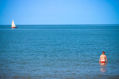 Rear view of woman standing in sea