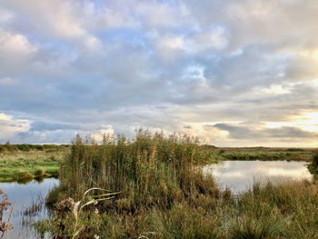 Scenic view of lake against cloudy sky