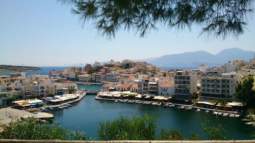 River by cityscape against clear sky