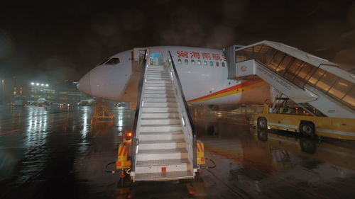 Airplane at airport against sky at night