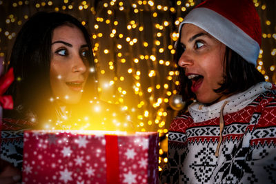 Portrait of young woman holding christmas tree