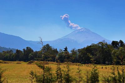 Scenic view of mountain peak against blue sky