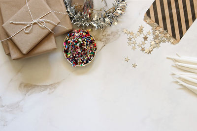 High angle view of confetti with candles and gifts on marble