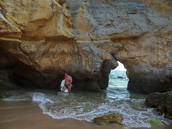 Man standing on rock by sea