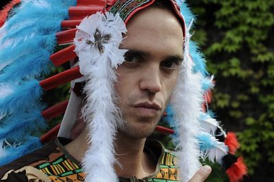 Portrait of man holding feathers