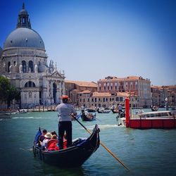 Boats in river with buildings in background