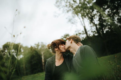 Young couple on plant against trees