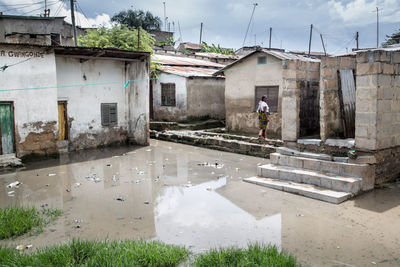 Reflection of houses in puddle against sky