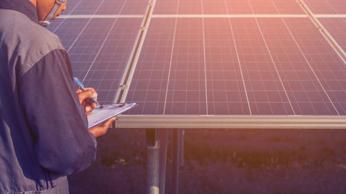 Male engineer examining solar panel