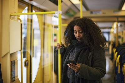 Woman in bus using cell phone
