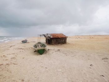 Lifeguard hut on beach against sky