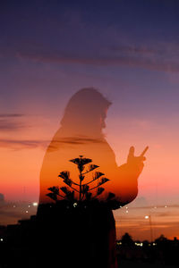 Silhouette of man using his phone mixed with sunset and night lights