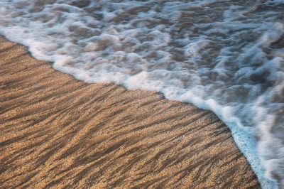 Close-up of sand at beach against sky