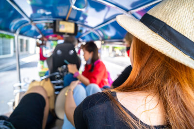 A group of asian tourists are traveling to bangkok in thailand. take a tuk-tuk
