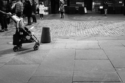 Low section of woman walking on sidewalk in city