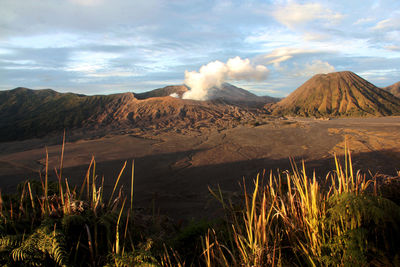 Smoke emitting from volcanic mountain against sky