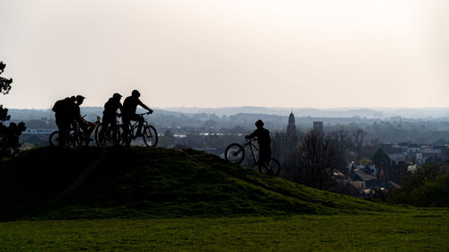 Teens meeting at bicycle riding track set against sky