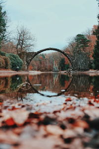 Reflection of arch bridge over river during autumn