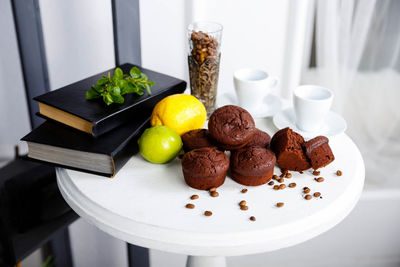 Chocolate cupcakes with coffee beans on a white wooden table