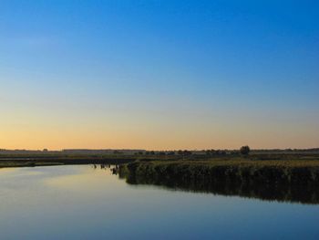 Scenic view of lake against clear blue sky