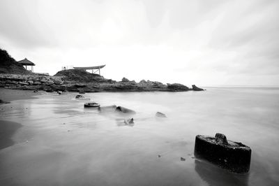 Scenic view of rocks on sea against sky